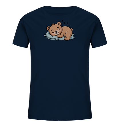 Onlineshop Shirts fuer Kinder - Das Bild zeigt ein dunkelblaues Kinder-T-Shirt mit einem niedlichen Tiermotiv. Auf der Vorderseite ist ein brauner Cartoon-Baer abgebildet, der friedlich auf einem hellblauen Kissen schlaeft. Über dem Kopf des Baeren sind "Zzz"-Symbole zu sehen, die seinen Schlafzustand darstellen. Das gesamte Design wirkt ruhig und charmant, ideal fuer ein Kinderkleidungsstueck.