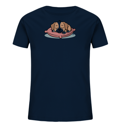 Onlineshop Shirts fuer Kinder - Das Bild zeigt ein dunkelblaues Kinder-T-Shirt mit einem niedlichen Aufdruck. Auf der Vorderseite ist ein schlafender Welpe in warmen Brauntoenen dargestellt, der gemuetlich auf einem rosa Kissen liegt. Der Welpe hat geschlossene Augen und wirkt sehr friedlich. Dieses verspielte Motiv verleiht dem Shirt einen charmanten und beruhigenden Charakter.