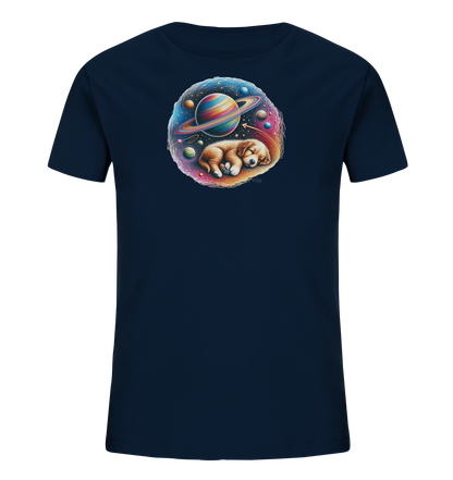Onlineshop Shirts fuer Kinder - Dieses dunkelblaue T-Shirt fuer Kinder zeigt eine runde Grafik in der Mitte. Das Motiv stellt einen schlafenden Welpen dar, der inmitten einer farbenpraechtigen Weltraumlandschaft liegt. Es sind ein grosser Planet mit Ringen sowie weitere Himmelskoerper und Sterne zu sehen. Die Illustration ist detailreich und zeigt einen traeumenden Hund im Kosmos.