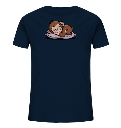 Onlineshop Shirts fuer Kinder - Das Bild zeigt ein dunkelblaues Kinder-T-Shirt. Auf der Vorderseite ist ein suesses, braunes Äffchen abgebildet, das friedlich auf einem violetten Kissen schlaeft. Das Äffchen hat die Augen geschlossen und ein leichtes Laecheln, was eine ruhige Szene darstellt. Das Design wirkt verspielt und liebevoll, passend fuer ein Kinderoberteil.