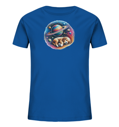 Onlineshop Shirts fuer Kinder - Das Bild zeigt ein blaues T-Shirt fuer Kinder mit einem farbenfrohen Aufdruck. Dieser zeigt einen niedlichen, schlafenden Welpen, eingebettet in eine Darstellung des Kosmos. Um den Welpen herum sind Planeten, Sterne und eine nebelartige Struktur in leuchtenden Farben wie Orange, Rosa und Blau zu sehen. Das Motiv ist kreisfoermig und vermittelt eine traeumerische und friedliche Atmosphaere.