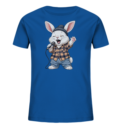 Onlineshop Shirts fuer Kinder - Das Bild zeigt ein leuchtend blaues Kinder-T-Shirt mit einem niedlichen Hasenmotiv auf der Vorderseite. Der Hase traegt ein kariertes Hemd, Jeansshorts und eine Muetze, waehrend er in ein Mikrofon singt. Seine Mimik drueckt Freude aus, mit geschlossenen Augen und einem geoeffneten Mund. Das Design wirkt verspielt und dynamisch, ideal fuer junge Musikfans.