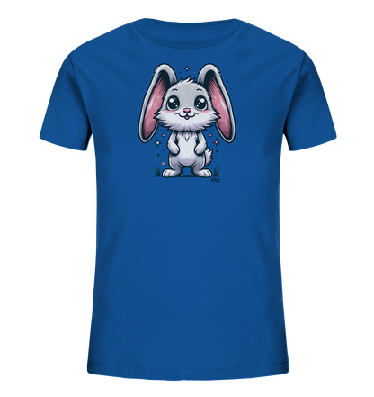 Onlineshop Shirts fuer Kinder - Das Bild zeigt ein blaues Kinder-T-Shirt mit einer niedlichen Illustration eines weissen Hasen auf der Vorderseite. Der Hase hat grosse rosa Ohren und funkelnde Augen und steht laechelnd auf einer angedeuteten Grasflaeche. Kleine Sterne und Pflanzen umgeben ihn. Das Design wirkt freundlich und verspielt.
