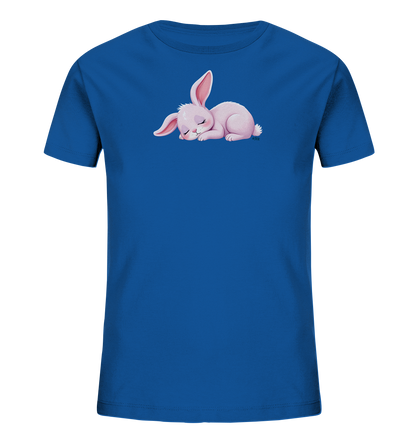 Onlineshop Shirts fuer Kinder - Das Bild zeigt ein blaues Kinder-T-Shirt mit einem mittig platzierten Motiv eines schlafenden rosa Kaninchens. Das Kaninchen liegt friedlich auf der Seite, die Augen geschlossen und die Ohren leicht nach hinten gelegt. Das Design ist detailliert und wirkt sehr ruhig und sanft. Das T-Shirt ist glatt und unifarben, was das Motiv hervorhebt.