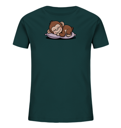 Onlineshop Shirts fuer Kinder - Das Bild zeigt ein dunkelgruenes Kinder-T-Shirt mit einem niedlichen Motiv auf der Vorderseite. Darauf ist ein brauner, schlafender Baby-Affe abgebildet, der gemuetlich auf einem lilafarbenen Kissen ruht. Der Affe hat die Augen geschlossen und einen friedlichen Ausdruck. Das Motiv ist zentral auf dem Shirt platziert.