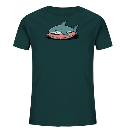 Onlineshop Shirts fuer Kinder - Das Bild zeigt ein dunkelgruen-blaues Kinder-T-Shirt. Auf der Vorderseite befindet sich eine Illustration eines friedlich schlafenden Hais. Der hellgraue Hai liegt bequem auf einem rosafarbenen Kissen, mit geschlossenen Augen und einem sanften Ausdruck. Das Motiv strahlt Ruhe und Freundlichkeit aus und ist ideal fuer Kinder.