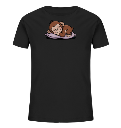 Onlineshop Shirts fuer Kinder - Das Bild zeigt ein schwarzes Kinder-T-Shirt mit einer niedlichen Darstellung eines schlafenden Äffchens auf der Vorderseite. Das Äffchen ist in braunen Farbtoenen gehalten und liegt friedlich auf einem hellvioletten Kissen mit geschlossenen Augen. Die Illustration wirkt sanft und beruhigend, ideal fuer Kinder.