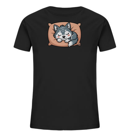 Onlineshop Shirts fuer Kinder - Das Bild zeigt ein schwarzes Kinder-T-Shirt mit einem charmanten Motiv. Auf der Vorderseite ist ein schlafender Wolfswelpe abgebildet, der gemuetlich auf einem beigen Kissen liegt. Der Welpe hat geschlossene Augen und rosige Wangen, was einen friedlichen Ausdruck vermittelt. Das Design ist liebevoll gestaltet und wirkt sehr niedlich.