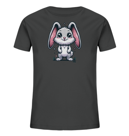 Onlineshop Shirts fuer Kinder - Das Bild zeigt ein anthrazitfarbenes T-Shirt fuer Kinder mit einem niedlichen, cartoonhaften Hasenmotiv auf der Vorderseite. Der Hase ist weiss mit grossen rosa Ohren und hat grosse Augen sowie ein freundliches Laecheln. Er steht auf einem kleinen Stueck Boden mit Gras und wenigen Blueten, umgeben von funkelnden Elementen. Das Design wirkt verspielt und ansprechend.