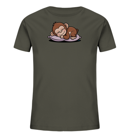 Onlineshop Shirts fuer Kinder - Das Bild zeigt ein erdgruenes Kinder-T-Shirt mit einem niedlichen Aufdruck auf der Vorderseite. Darauf ist ein braunes, schlafendes Äffchen zu sehen, das friedlich auf einem hellvioletten Kissen liegt. Das Äffchen ist mit geschlossenen Augen und einem zufriedenen Ausdruck dargestellt. Das Design wirkt ruhig und kindgerecht.