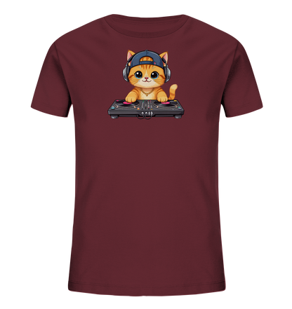 Onlineshop Shirts fuer Kinder - Das Bild zeigt ein bordeauxrotes Kinder-T-Shirt mit einer charmanten Cartoon-Katze als Motiv. Die orangefarbene Katze traegt eine blaue Kappe und Kopfhoerer, waehrend sie an einem DJ-Mischpult steht. Mit ihren grossen blauen Augen und einer goldenen Kette wirkt sie verspielt und cool. Das Design verleiht dem Shirt einen modernen und lustigen Look.