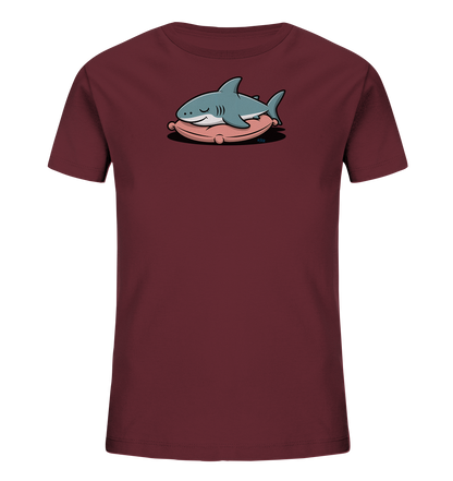 Onlineshop Shirts fuer Kinder - Das Bild zeigt ein dunkelrotes Kinder-T-Shirt. Auf der Vorderseite ist eine niedliche Illustration eines schlafenden Hais zu sehen. Der hellblaue Hai liegt gemuetlich auf einem rosa Kissen, was einen entspannten und freundlichen Eindruck vermittelt. Das Design ist verspielt und ideal fuer Kinder.