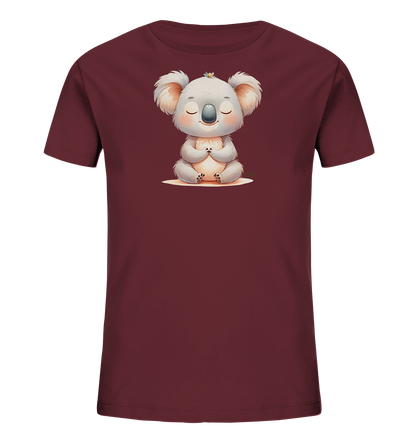 Onlineshop Shirts fuer Kinder - Das Bild zeigt ein dunkelrotes Kinder-T-Shirt mit einer niedlichen Illustration eines meditierenden Koalas auf der Vorderseite. Der Koala sitzt im Schneidersitz, hat die Augen geschlossen und die Pfoten zusammengelegt. Eine kleine gelbe Blume ziert seinen Kopf, was dem Motiv eine ruhige und friedliche Ausstrahlung verleiht.