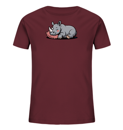 Onlineshop Shirts fuer Kinder - Das Bild zeigt ein bordeauxfarbenes Kinder-T-Shirt mit einem niedlichen Aufdruck auf der Vorderseite. Darauf ist ein graues, schlafendes Nashorn zu sehen, das friedlich auf einem rosa Kissen liegt. Das Nashorn hat geschlossene Augen und rosige Wangen, was dem Motiv einen sanften und beruhigenden Ausdruck verleiht. Dieses Design wirkt verspielt und ansprechend fuer junge Kinder.