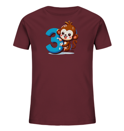 Onlineshop Shirts fuer Kinder - Das Bild zeigt ein dunkelrotes Kinder-T-Shirt mit einem froehlichen Cartoon-Affen. Der Affe haelt sich an einer grossen, blauen Zahl '3' fest und laechelt. Das Design wirkt verspielt und ist ideal fuer kleine Kinder.