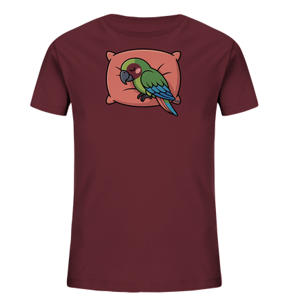 Onlineshop Shirts fuer Kinder - Das Bild zeigt ein weinrotes T-Shirt fuer Kinder. Im Vordergrund ist eine Illustration eines schlafenden gruenen Vogels mit blauen Fluegeln zu sehen, der auf einem weichen, pfirsichfarbenen Kissen liegt. Die Farbgebung des Motivs ist sanft und harmonisch. Das gesamte Design wirkt ruhig und ansprechend fuer Kinder.