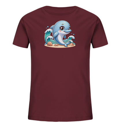 Onlineshop Shirts fuer Kinder - Das Bild zeigt ein dunkelrotes T-Shirt fuer Kinder mit einem farbenfrohen Druck. Auf der Vorderseite ist ein laechelnder, blauer Delfin dargestellt, der inmitten von Wellen schwimmt. Unter dem Delfin ist eine Sandflaeche mit Muscheln zu sehen, was dem Design einen maritimen Touch verleiht. Dieses Motiv wirkt freundlich und verspielt, ideal fuer Kindermode.
