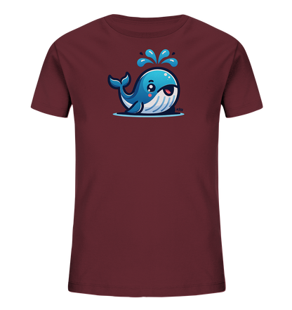Onlineshop Shirts fuer Kinder - Das Bild zeigt ein Kinder-T-Shirt in einem tiefen Rotton. Auf der Vorderseite ist eine niedliche, cartoonartige Illustration eines blauen Wals abgebildet. Der Wal spritzt Wasser aus seinem Blasloch und hat ein freundliches, laechelndes Gesicht. Das Design ist verspielt und ansprechend gestaltet.