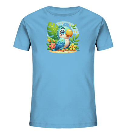Onlineshop Shirts fuer Kinder - Das Bild zeigt ein hellblaues Kinder-T-Shirt mit einem farbenfrohen Aufdruck. Dieser zeigt einen niedlichen Cartoon-Papagei, umgeben von tropischen Pflanzen und Blumen. Der Papagei sitzt auf Sand vor einem runden, blauen Hintergrund mit Sternen. Das Design wirkt froehlich und detailreich.