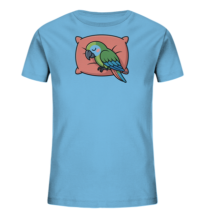 Onlineshop Shirts fuer Kinder - Das Bild zeigt ein hellblaues Kinder-T-Shirt mit einem niedlichen Motiv auf der Vorderseite. Ein kleiner, gruener Papagei mit blauen Fluegeln schlaeft friedlich auf einem rosafarbenen Kissen. Der Vogel hat die Augen geschlossen und vermittelt einen ruhigen, entspannten Eindruck. Dieses verspielte Design verleiht dem T-Shirt einen sanften und kinderfreundlichen Charakter.