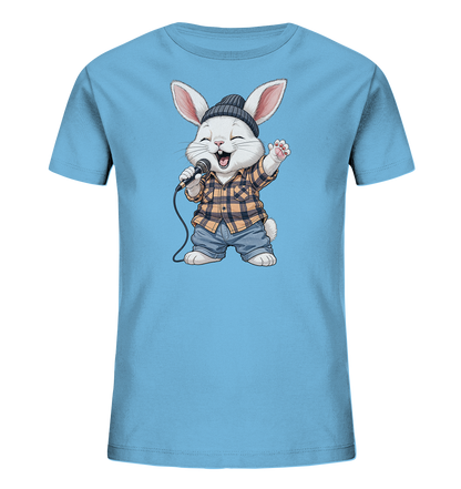 Onlineshop Shirts fuer Kinder - Das Bild zeigt ein hellblaues Kinder-T-Shirt mit einem niedlichen Kaninchenmotiv auf der Vorderseite. Das Kaninchen traegt ein kariertes Hemd, Jeansshorts und eine dunkle Muetze, waehrend es in ein Mikrofon singt. Es hat eine froehliche Mimik mit geschlossen Augen und geoeffnetem Mund. Das Design verleiht dem Shirt einen verspielten und musikalischen Charakter.
