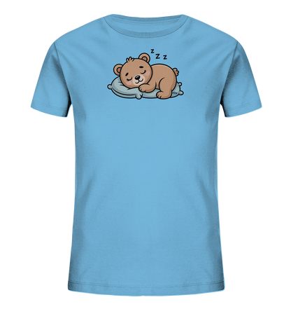 Onlineshop Shirts fuer Kinder - Das Bild zeigt ein hellblaues Kinder-T-Shirt. Auf der Vorderseite ist ein niedlicher brauner Baer abgebildet, der friedlich auf einem hellblauen Kissen schlaeft. Über dem Kopf des Baeren sind 'Zzz'-Symbole zu sehen, die seinen Schlaf andeuten. Das Design wirkt beruhigend und ist ideal fuer kleine Schlafmuetzen.