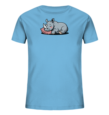 Onlineshop Shirts fuer Kinder - Das Bild zeigt ein hellblaues T-Shirt fuer Kinder. Auf der Vorderseite ist eine niedliche, cartoonartige Illustration eines schlafenden Nashorns zu sehen. Das graue Nashorn liegt entspannt auf einem rosafarbenen Kissen, mit geschlossenen Augen und einem sanften Ausdruck. Das Design wirkt beruhigend und verspielt.
