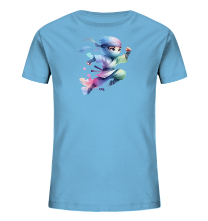 Onlineshop Shirts fuer Kinder - Das Bild zeigt ein hellblaues Kinder T-Shirt mit einem farbenfrohen Aufdruck auf der Vorderseite. Zu sehen ist eine niedliche, springende Figur im Stil eines Ninja in einer dynamischen Pose. Die Figur traegt ein helles Outfit mit bunten Akzenten in Rosa, Lila und Gruen und ist von abstrakten Farbspritzern umgeben. Das Motiv wirkt verspielt und energiegeladen.
