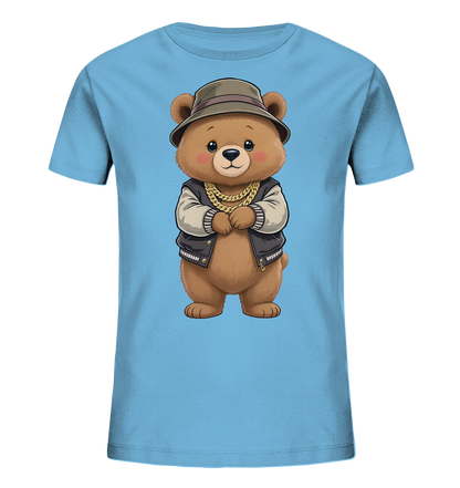 Onlineshop Shirts fuer Kinder - Das Bild zeigt ein hellblaues Kinder-T-Shirt mit einer zentralen Illustration. Auf der Vorderseite ist ein brauner Cartoon-Baer zu sehen, der eine Bomberjacke, einen Fischerhut und eine goldene Kette traegt. Der Baer hat einen freundlichen Ausdruck und verschraenkte Arme. Das Design ist detailliert und ansprechend.
