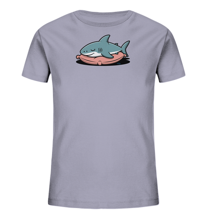 Onlineshop Shirts fuer Kinder - Das Bild zeigt ein hellgraues Kinder-T-Shirt mit einem niedlichen Motiv eines schlafenden Hais. Der hellblaue Hai liegt gemuetlich auf einem ovalen, rosa Kissen. Seine Augen sind geschlossen, und er hat ein sanftes Laecheln im Gesicht, was eine friedliche Ausstrahlung verleiht. Das Design ist zentral auf der Vorderseite des Shirts platziert und sticht durch die Farben hervor.