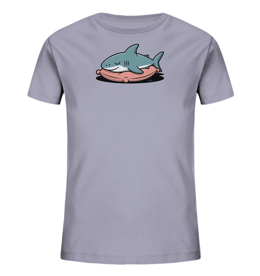Onlineshop Shirts fuer Kinder - Das Bild zeigt ein hellgraues Kinder-T-Shirt mit einem niedlichen Motiv eines schlafenden Hais. Der hellblaue Hai liegt gemuetlich auf einem ovalen, rosa Kissen. Seine Augen sind geschlossen, und er hat ein sanftes Laecheln im Gesicht, was eine friedliche Ausstrahlung verleiht. Das Design ist zentral auf der Vorderseite des Shirts platziert und sticht durch die Farben hervor.