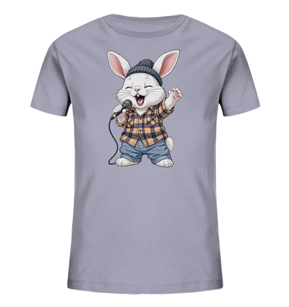 Onlineshop Shirts fuer Kinder - Das Bild zeigt ein hellgraues Kinder-T-Shirt mit einem lustigen Motiv eines Hasen, der singt. Der Hase traegt eine dunkle Muetze, ein kariertes Hemd und kurze Jeanshosen. Er haelt ein Mikrofon und hat einen froehlichen Gesichtsausdruck, als wuerde er gerade performen. Das Design wirkt verspielt und dynamisch.
