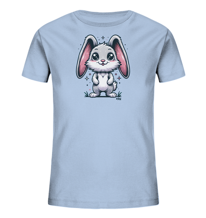 Onlineshop Shirts fuer Kinder - Das Bild zeigt ein hellblaues T-Shirt fuer Kinder mit einem niedlichen Comic-Motiv eines weissen Kaninchens. Das Kaninchen hat grosse rosafarbene Ohren und steht auf einer kleinen Flaeche mit Gras. Funkelnde Sterne und Lichteffekte umgeben das freundlich laechelnde Tier. Das Design ist detailreich und ansprechend gestaltet.