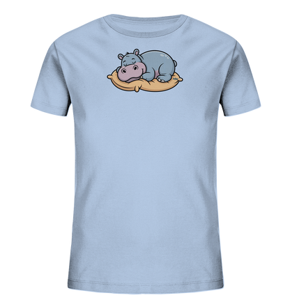 Onlineshop Shirts fuer Kinder - Das Bild zeigt ein hellblaues Kinder-T-Shirt mit einem niedlichen Motiv eines schlafenden Nilpferds. Das Nilpferd liegt gemuetlich auf einem beigen Kissen, hat die Augen geschlossen und wirkt sehr friedlich. Die Illustration ist im Cartoon-Stil gehalten und verleiht dem Shirt einen verspielten und beruhigenden Charakter.