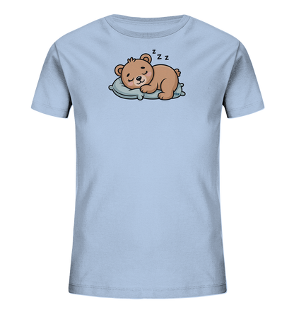 Onlineshop Shirts fuer Kinder - Das Bild zeigt ein hellblaues Kinder-T-Shirt mit einem niedlichen Motiv. Darauf ist ein brauner Cartoon-Baer abgebildet, der friedlich auf einem hellblauen Kissen schlaeft. Über dem Baerenkopf sind Zzz-Symbole zu sehen, die seinen Schlafzustand darstellen. Das Design verleiht dem T-Shirt einen beruhigenden und charmanten Charakter.