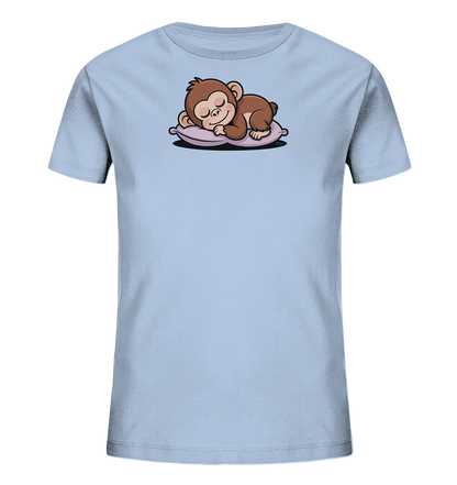 Onlineshop Shirts fuer Kinder - Das Bild zeigt ein hellblaues T-Shirt fuer Kinder, das ein suesses, schlafendes Äffchen auf der Vorderseite darstellt. Das braune Äffchen liegt friedlich auf einem violetten Kissen, die Augen geschlossen und mit einem sanften Laecheln. Dieses Motiv verleiht dem Shirt einen liebevollen und beruhigenden Charakter.