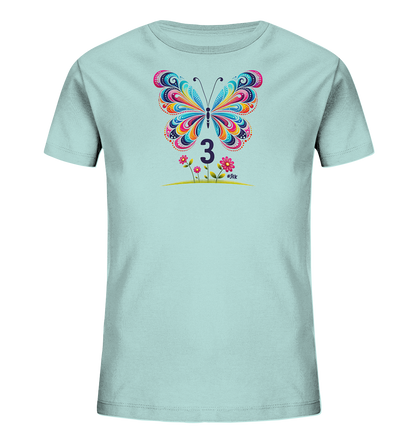 Onlineshop Shirts fuer Kinder - Das Bild zeigt ein hellblaues Kinder-T-Shirt mit einem grossen, farbenfrohen Schmetterlingsdesign auf der Vorderseite. Darunter befindet sich die Zahl 3. Das Motiv wird durch kleine Blumen und Gras ergaenzt, was dem Shirt ein froehliches Aussehen verleiht.