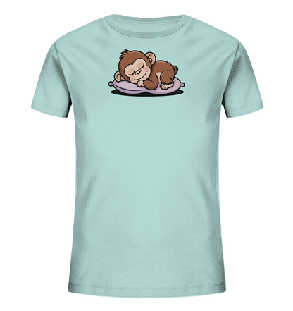 Onlineshop Shirts fuer Kinder - Das Bild zeigt ein hellblaues Kinder-T-Shirt mit einem niedlichen Motiv eines schlafenden Äffchens. Das braune Äffchen liegt friedlich auf einem lilafarbenen Kissen, die Augen geschlossen. Das Design wirkt beruhigend und ist ideal fuer kleine Kinder. Das T-Shirt ist glatt und faltenfrei auf einem dunklen Hintergrund abgebildet.