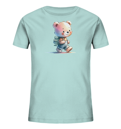 Onlineshop Shirts für Kinder - Das Bild zeigt ein hellblaues Kinder-T-Shirt mit einem niedlichen Motiv eines kleinen Bären auf der Vorderseite. Der cartoonhafte Bär läuft mit einem freundlichen Lächeln, trägt einen kleinen Rucksack auf dem Rücken und Latzhosen. Die Illustration ist in einem sanften Aquarell-Stil ausgeführt. Neben dem Rucksack befindet sich ein kleines Hashtag "#Sfk", das das Design ergänzt.