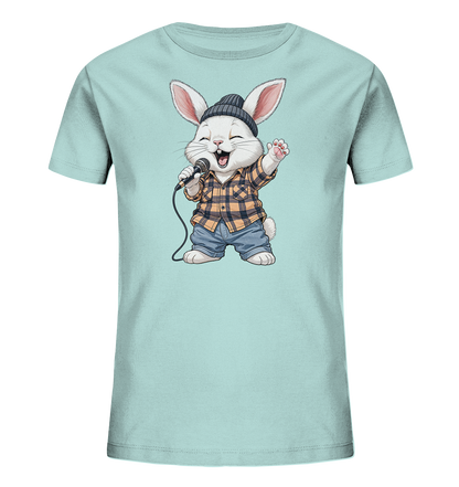 Onlineshop Shirts fuer Kinder - Das Bild zeigt ein hellblaues T-Shirt mit einem niedlichen Cartoon-Motiv eines singenden Hasen. Der Hase traegt ein kariertes Hemd, Jeansshorts und eine dunkle Muetze. Er haelt ein Mikrofon und hat einen froehlichen, offenen Mund. Das Design wirkt lebhaft und ansprechend fuer Kinder.