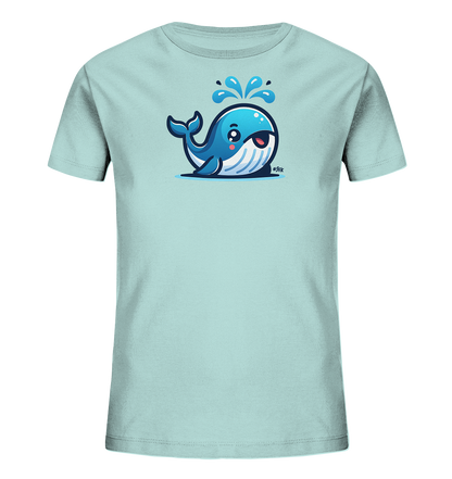 Onlineshop Shirts fuer Kinder - Das Bild zeigt ein hellblaues T-Shirt mit einem farbenfrohen Comic-Motiv auf der Vorderseite. Abgebildet ist ein freundlich laechelnder blauer Wal, der Wasser aus seinem Blasloch spritzt. Das Design ist froehlich und verspielt, ideal fuer Kinderkleidung. Das T-Shirt liegt flach auf einem neutralen Hintergrund praesentiert.