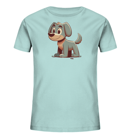 Onlineshop Shirts fuer Kinder - Das Bild zeigt ein hellblaues Kinder T-Shirt mit einem Cartoon-Motiv eines Hundes auf der Vorderseite. Der Hund hat graublaues Fell, braune Details an Ohren und Schnauze sowie grosse, freundliche Augen. Er sitzt laechelnd auf einer kleinen gruenen Flaeche, die Gras darstellt. Die Illustration ist in einem einfachen, freundlichen Stil gehalten.