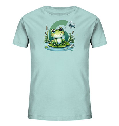 Onlineshop Shirts fuer Kinder - Das Bild zeigt ein hellblaues Kinder-T-Shirt mit einem froehlichen Froschmotiv. Der Cartoon-Frosch sitzt auf einem Seerosenblatt in einem Teich, umgeben von Schilf und Wasserlilien. Im Hintergrund ist prominent die Zahl Sechs zu sehen, und eine Libelle schwebt darueber. Das Design ist farbenfroh und detailreich, perfekt fuer Kinder.
