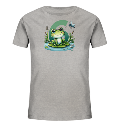 Onlineshop Shirts fuer Kinder - Das Bild zeigt ein hellgraues Kinder-T-Shirt mit einem farbenfrohen Motiv. Darauf ist ein freundlicher Cartoon-Frosch abgebildet, der auf einem Seerosenblatt in einem Teich sitzt. Im Hintergrund ist eine grosse gruene Zahl '6' zu sehen, und eine Libelle fliegt darueber, umgeben von Schilf. Das Design hat einen froehlichen Natur-Charakter.