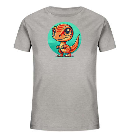 Onlineshop Shirts fuer Kinder - Das Bild zeigt ein graues Kinder-T-Shirt mit einem farbenfrohen Cartoon-Motiv auf der Vorderseite. Im Zentrum steht ein kleiner, orangefarbener Dinosaurier mit grossen Augen und freundlichem Ausdruck. Er ist aufrecht stehend vor einem runden, tuerkisfarbenen Hintergrund mit horizontalen Streifen dargestellt. Das Design wirkt froehlich und verspielt.