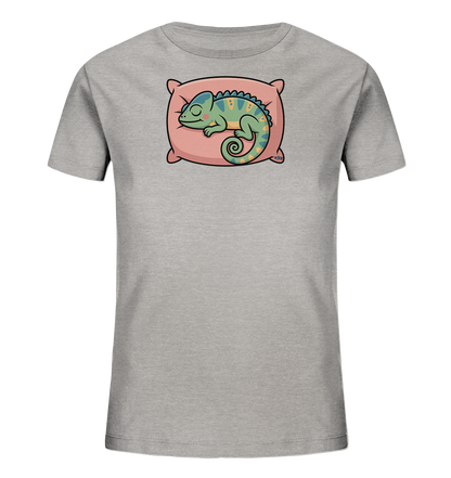 Onlineshop Shirts fuer Kinder - Das Bild zeigt ein hellgraues Kinder-T-Shirt mit einem niedlichen Motiv auf der Vorderseite. Im Zentrum ist ein friedlich schlafendes Chamaeleon auf einem rosa Kissen abgebildet. Das Chamaeleon ist gruenlich-blau mit gelben Akzenten und geringeltem Schwanz dargestellt. Dieses Design verleiht dem Shirt einen ruhigen und verspielten Charakter.