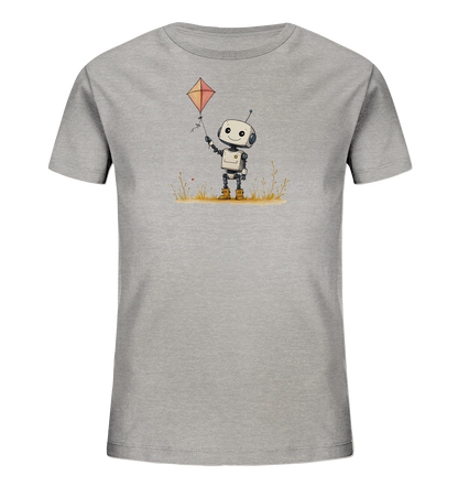 Onlineshop Shirts für Kinder - Das Bild zeigt ein graues Kinder-T-Shirt mit einem Aufdruck auf der Vorderseite. Die Illustration zeigt einen kleinen, freundlich aussehenden Roboter mit großen Augen und einer Antenne. Der Roboter steht in einer stilisierten Wiese und hält einen roten, rautenförmigen Drachen in der Hand. Kleine Akzente wie Grashalme und winzige rote Elemente ergänzen das verspielte Design.