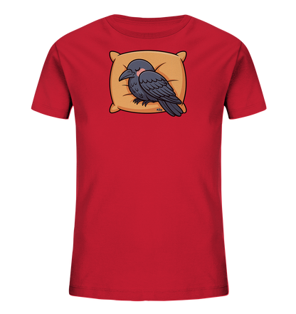Onlineshop Shirts fuer Kinder - Das rote Kinder-T-Shirt zeigt eine entzueckende Illustration eines schlafenden Raben oder einer Kraehe. Der Vogel ruht friedlich auf einem beigefarbenen Kissen mit geschlossenen Augen und leicht geroeteten Wangen. Das Motiv verleiht dem Shirt eine beruhigende und suesse Ausstrahlung, ideal fuer die Kleinsten. Es ist ein verspieltes Design in klaren Farben.