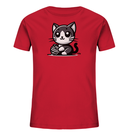 Onlineshop Shirts fuer Kinder - Das Bild zeigt ein rotes Kinder-T-Shirt mit einer suessen, cartoonhaften Illustration. Auf der Vorderseite ist eine schwarz-weisse Katze abgebildet, die mit einem Wollknaeuel spielt. Die Katze hat grosse Augen und sitzt aufrecht.
