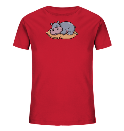 Onlineshop Shirts fuer Kinder - Das Bild zeigt ein rotes Kinder-T-Shirt. Auf der Vorderseite ist ein suesses, graues Nilpferd abgebildet, das friedlich auf einem beigefarbenen Kissen schlaeft. Das Nilpferd hat rosa Akzente und geschlossene Augen, was einen ruhigen und niedlichen Ausdruck vermittelt. Das Design ist schlicht und ansprechend fuer junge Traeger.